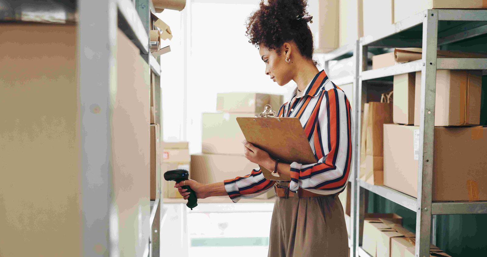 A worker scanning and tracking boxed items with a clipboard