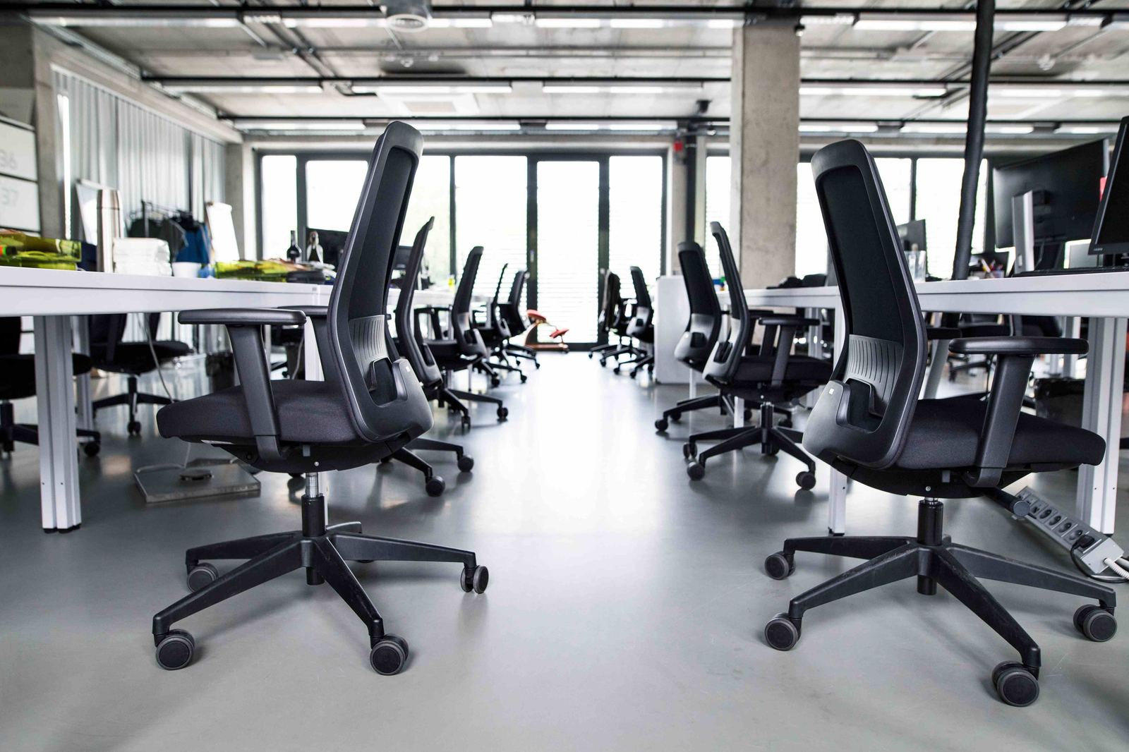 Office desks and chairs neatly stored in a commercial space